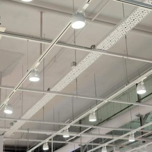 Ceiling with bright lights in a modern warehouse, shopping center building, office or other commercial real estate object. Directional LED lights on rails under the ceiling